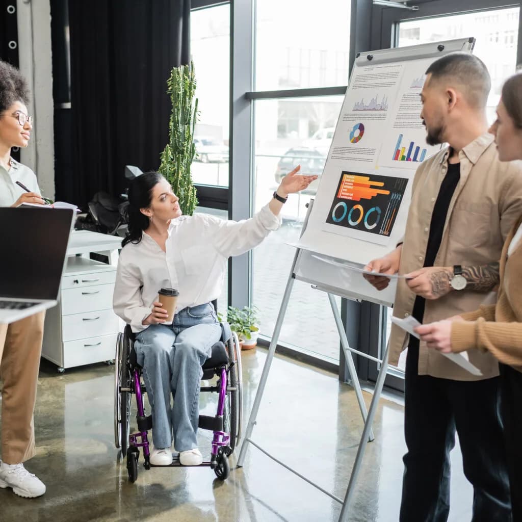 A wheelchair user presenting to colleagues during a workplace capacity assessment