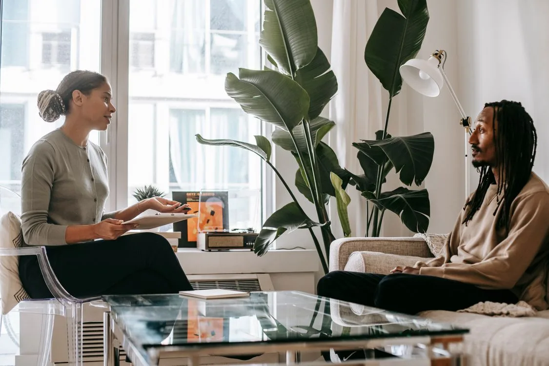 A therapist taking notes during a consultation with a client